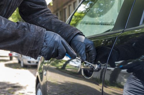 Eine Person versucht das Schloss an einem Fahrzeug aufzubrechen