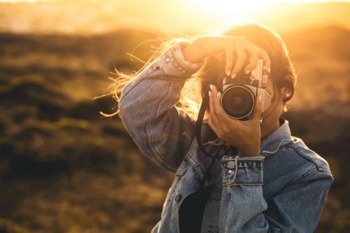 Frau hält Fotoapparat draußen 