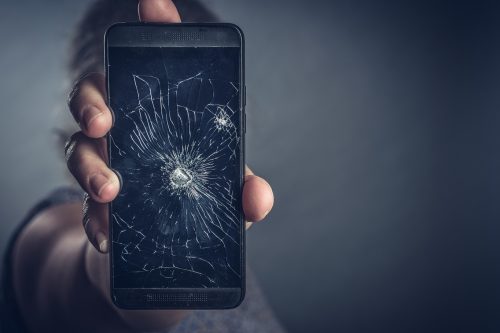 Zerstörtes Handy wird in Hand gehalten