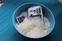 Handy und Akku liegen in Reis