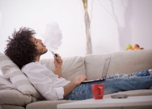 mann auf sofa mit e-zigarette
