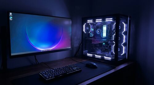 Gaming-PC mit beleuchteten Komponenten und Monitor auf dem Schreibtisch